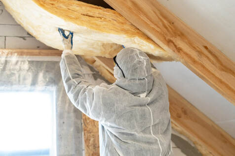 An image of a person working on an attic insulation service