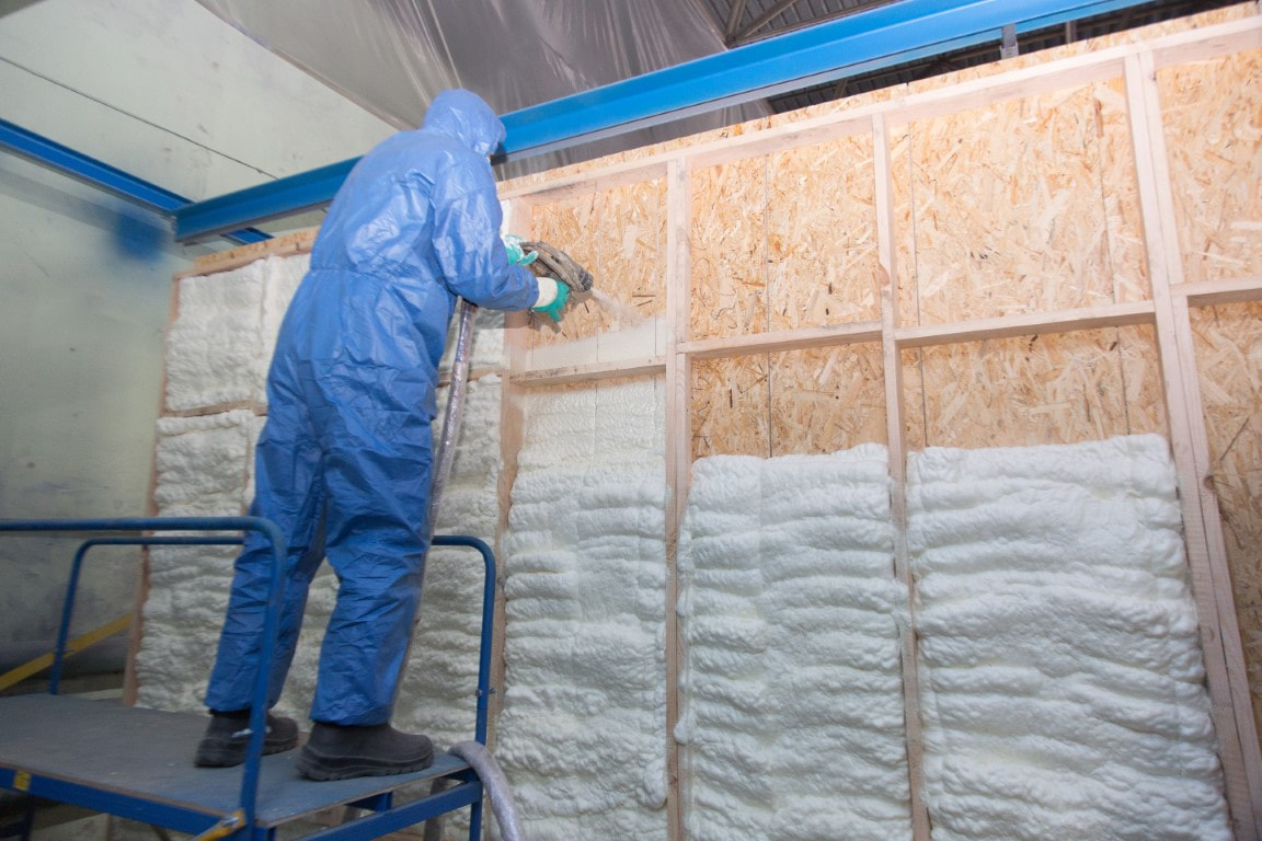 A picture of a person applying spray foam insulation